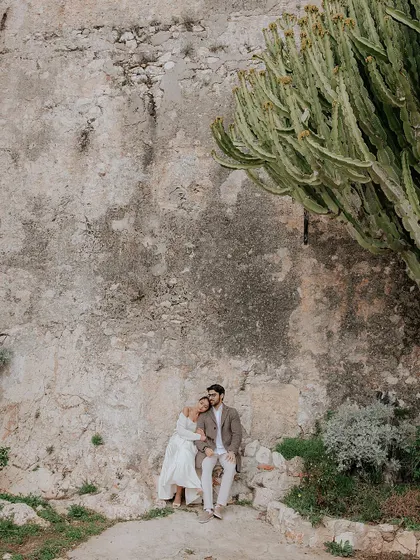 A quiet moment of togetherness for Brinda and Jeet, nestled against ancient stone walls and cacti on the French Riviera. This shot captures the rustic charm of the South of France.