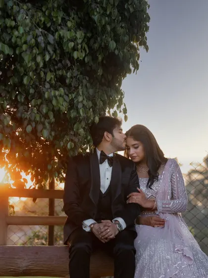 A romantic sunset portrait. The warm, golden light of the setting sun creates a beautiful, soft glow around the couple, perfectly capturing the romance of the moment.