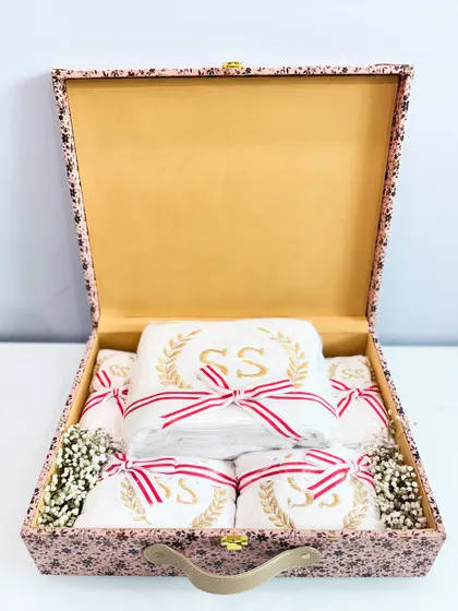 An open view of the custom bride box, showing the neatly packed, monogrammed towels.