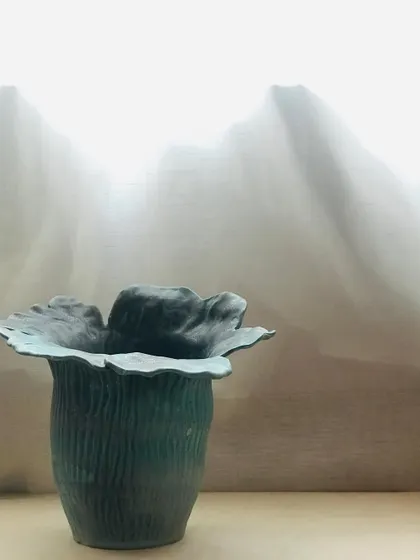 A side view of the Wild Petal Vase. The vertical texture on the body contrasts beautifully with the smooth, flowing lines of the rim.