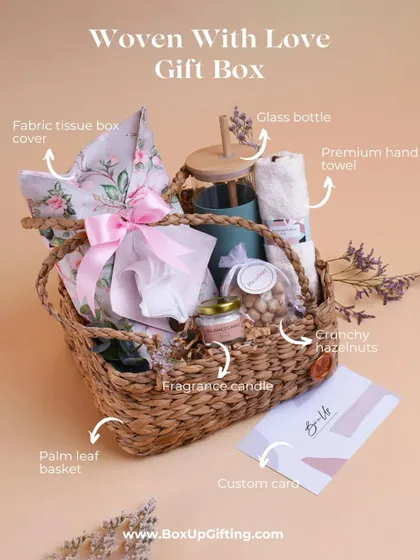 The "Woven With Love Gift Box" is a contemporary collection for the new-age woman. It includes a fabric tissue box cover, a glass bottle, a fragrance candle, and more in a palm leaf basket.