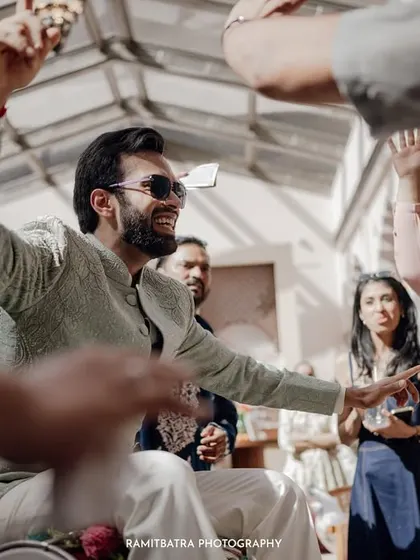 The groom makes a grand, energetic entrance, showering guests with currency notes in a moment of pure celebration.