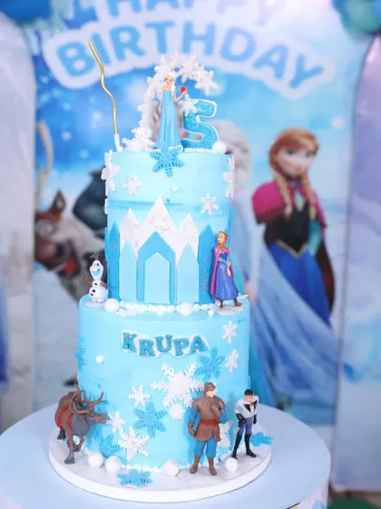 Here is my Frozen cake in its element, perfectly matching the party's backdrop. It’s so rewarding to see my creations become the centerpiece of such happy family moments.