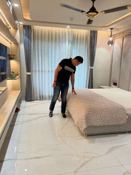 Final touches and inspection of the bed and flooring in this master suite.