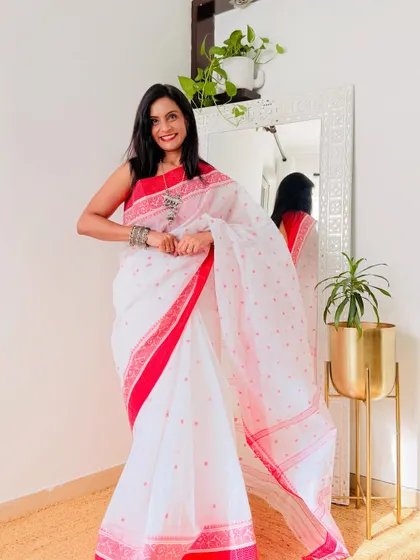 The classic Bengali Lal Paar saree in a soft Tant cotton. This white saree with a red border is timeless and elegant, perfect for any auspicious occasion.