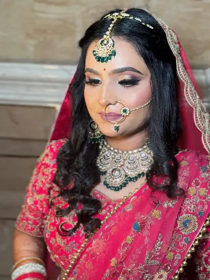 A classic portrait of a bride in her pink lehenga. Her makeup is soft and elegant, with a focus on clean skin and a beautiful smile.