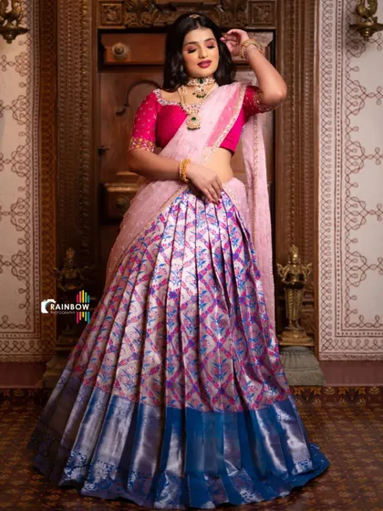 A full-length view of the model in the pink and blue half saree, showcasing the grand flare of the skirt.
