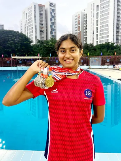 Ashmitha Chandra proudly displays her medals from the All India University Games, a result of her hard work in freestyle and relay events.