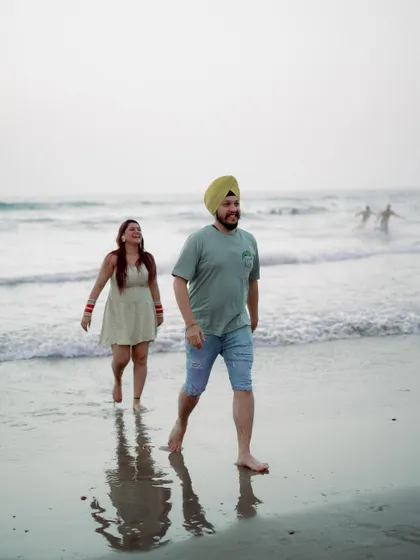 A fun, candid shot of the couple walking out of the water, sharing a laugh. These unposed moments are often the highlights of a pre-wedding session.