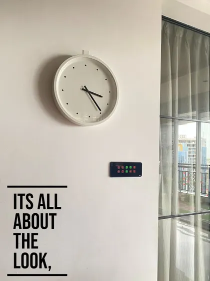 For us, it's all about the look. A smart panel should blend perfectly with your interior design, as shown here with this discreet black panel placed neatly below a minimalist wall clock.
