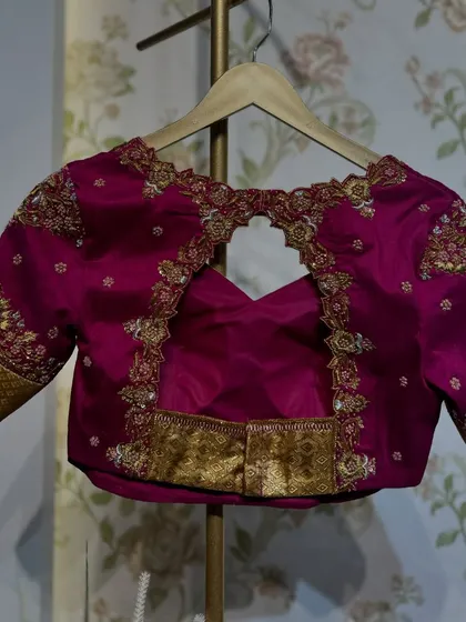 The back of the magenta and gold blouse, with a keyhole cut-out and intricate embroidery.
