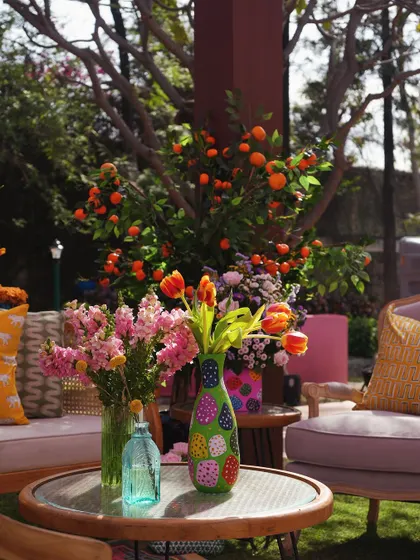 The seating areas featured a mix of colorful, hand-painted vases and fresh flowers, creating a cheerful and eclectic vibe.