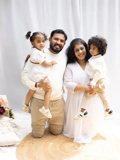 A classic outdoor family portrait. The family stands together, smiling, creating a beautiful and timeless memory in a natural setting.