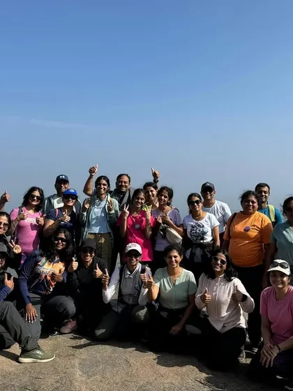 A happy corporate group gives a thumbs-up at a viewpoint. We focus on creating positive, stress-free experiences that boost team morale.