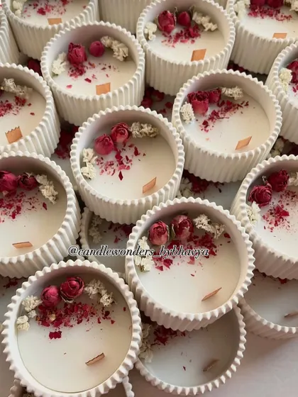 A close-up of the concrete jar candles, showing the beautiful texture of the jar and the delicate floral toppings.