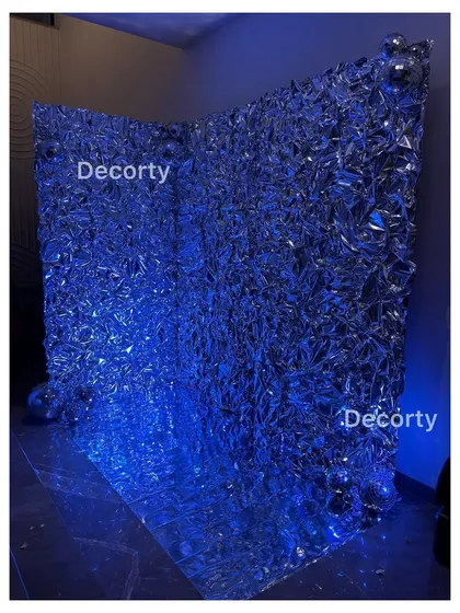The same foil backdrop illuminated with blue light, showing how it can be transformed to match any color scheme or party mood.