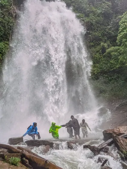 A group of trekkers carefully making their way across the rocks at the base of Hidlumane Falls.