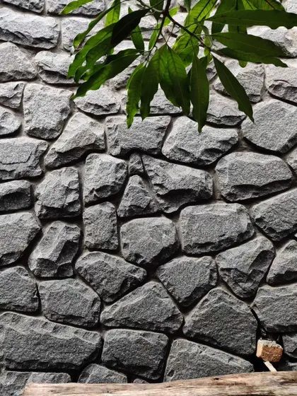 A close-up of the random rubble stone wall used in the Siri residence, showcasing the natural texture and craftsmanship.