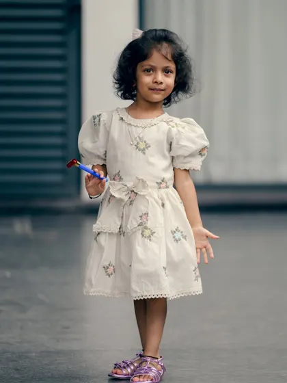 A full-length shot of a little girl looking curiously at the camera. These simple, direct portraits of children are often the most treasured.