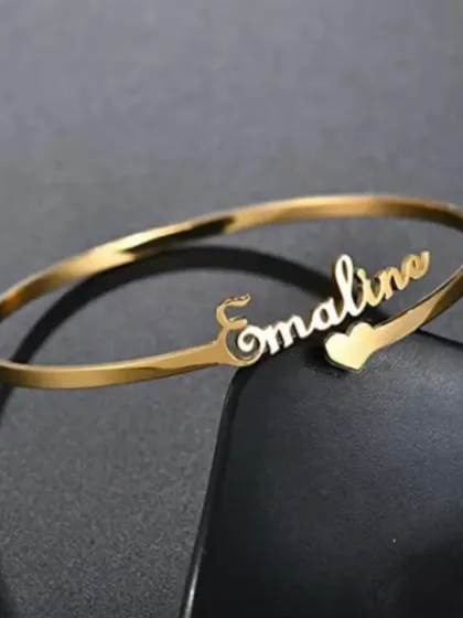 Simple, elegant, and personal. Our custom name bracelets are a classic for a reason. This piece features a delicate script name on a polished gold-finish bangle, making it a perfect everyday accessory or a heartfelt gift.
