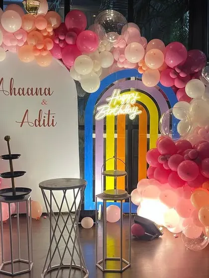 A close-up of the pastel-themed first birthday, showing the details of the balloon colors and the custom name sign.