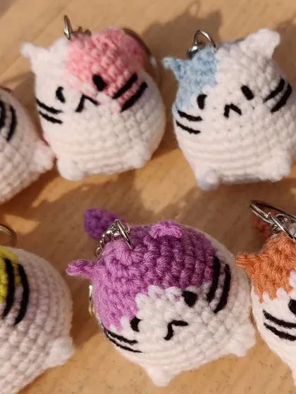 A close-up on the colorful, chubby cat charms.
