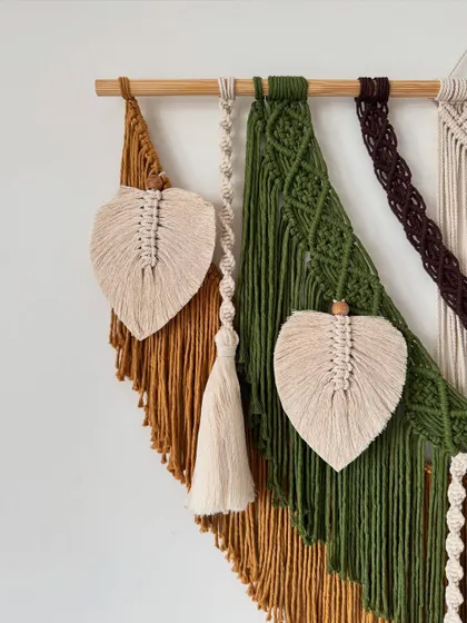 A side view highlighting the textures and layers of this large, multi-colored macrame wall hanging.