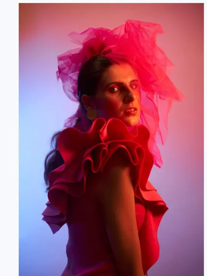Another angle from the "Badass Barbie" shoot. This image showcases the dramatic silhouette of the pink ruffle dress and tulle headpiece under creative, multi-colored lighting.