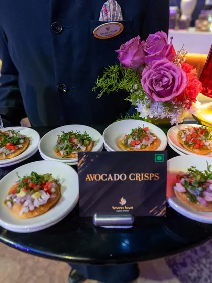 A tray of our popular Avocado Crisps, elegantly presented by a member of our service staff. These light and flavourful bites are a refreshing and healthy option for any corporate gathering.