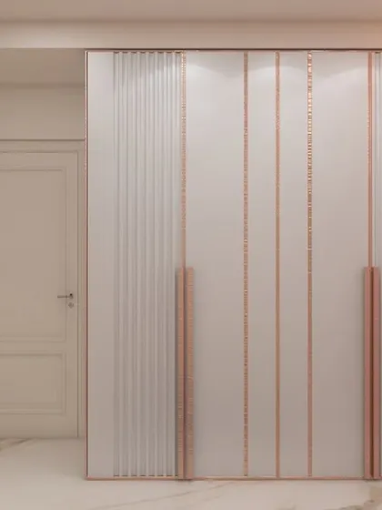 This image details a custom wardrobe for a kid's bedroom, featuring rose gold metallic inlays on white fluted doors. The design is both elegant and youthful, providing ample storage while enhancing the room's aesthetic.