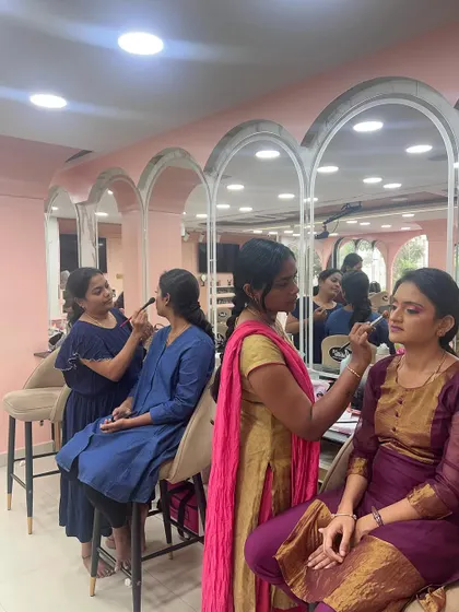 Students deep in concentration during a hands-on makeup practice session.