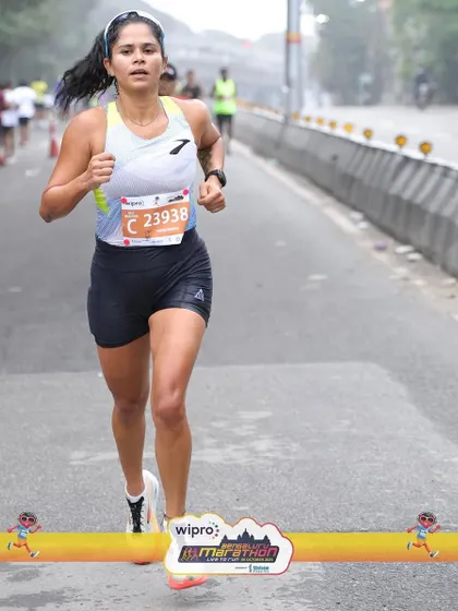 Driving forward on the road. Good running form, with a strong core and efficient arm swing, is visible here. We work on these details in training so they become second nature on race day.