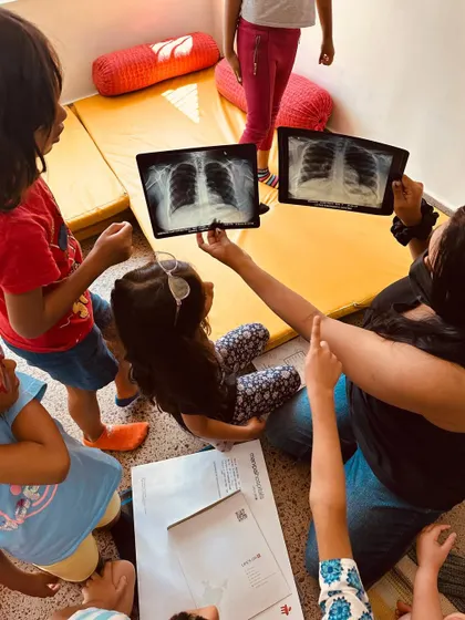 The children examine X-rays, taking on the role of pulmonologists for the day. Role-playing helps them process information and build empathy by stepping into someone else's shoes.