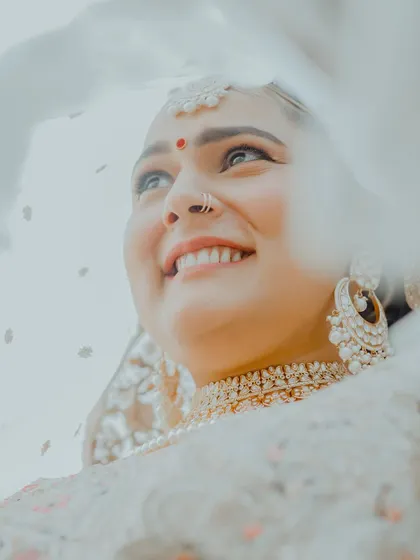 An artistic low-angle shot of the bride looking up, her face framed by her delicate veil. This portrait is hopeful, dreamy, and absolutely beautiful.