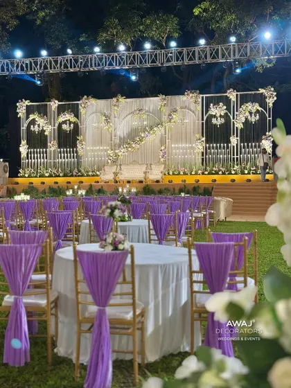 The elegant guest seating arrangement with lavender drapes, perfectly complementing the sophisticated stage design for a cohesive and beautiful event space.