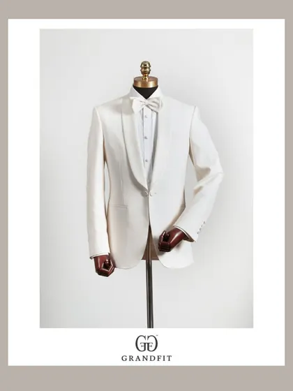 Beyond traditional wear, we craft exquisite formal ensembles. This classic white tuxedo, featuring a shawl collar and made-to-measure construction, is the pinnacle of reception and black-tie elegance.