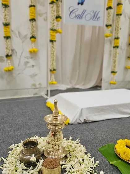 We pay close attention to the details of the ceremony itself. This setup includes a traditional brass Nilavilakku (lamp) placed on a bed of fresh flowers, ready for the sacred rituals of the naming ceremony.