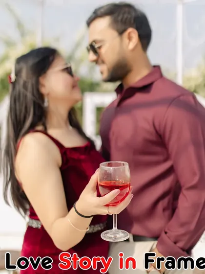 A close-up shot focusing on the couple's connection, with a glass of wine as a prop, set against the blurred backdrop of a "Marry Me" sign.