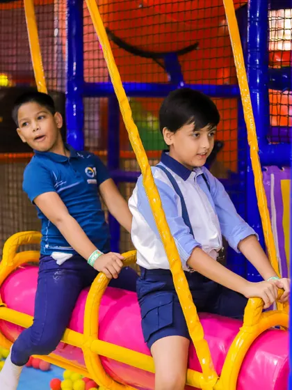 Teamwork on the swinging log. This activity encourages kids to play together and develop balance and coordination in the ball pit area.