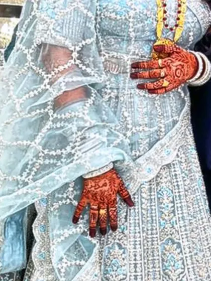 The beautiful contrast of a deep henna stain against a lovely light blue outfit.