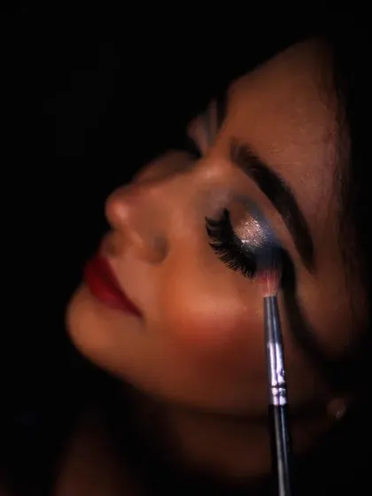 A close-up of the reception eye makeup application. I'm using a glittery, silver-blue eyeshadow to create a dramatic, sparkling effect that catches the light beautifully.