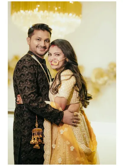 A classic couple portrait with beautiful lighting from a chandelier. The couple looks elegant and happy in their coordinated outfits.