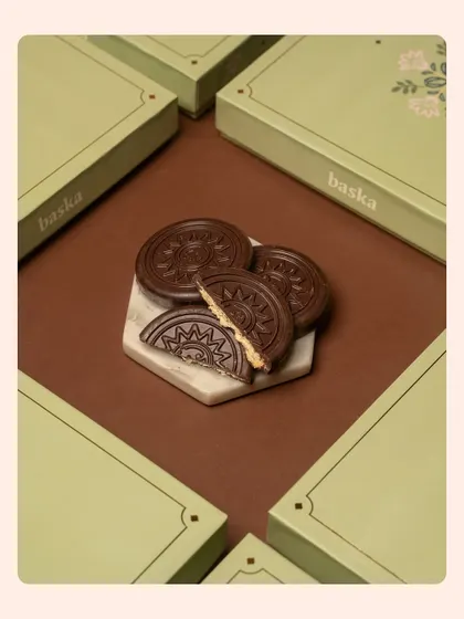 A creative shot of embossed chocolate coins for a Rakshabandhan collection. The geometric arrangement of the boxes creates a modern and visually interesting composition.