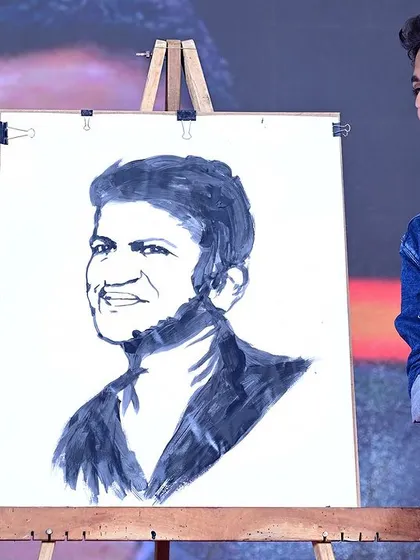Presenting my completed portrait of Puneeth Rajkumar on stage. This piece is a heartfelt tribute, and performing it live allows me to share that emotion with a large audience.