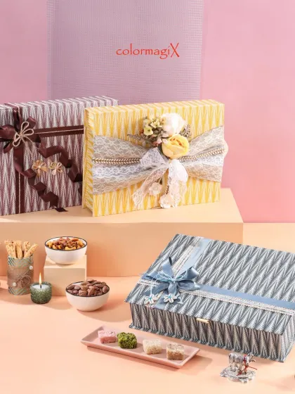 Three of our designer festive gift hampers in different colors and ribbon styles. The textured finish and floral embellishments make these a luxurious choice for any celebration.