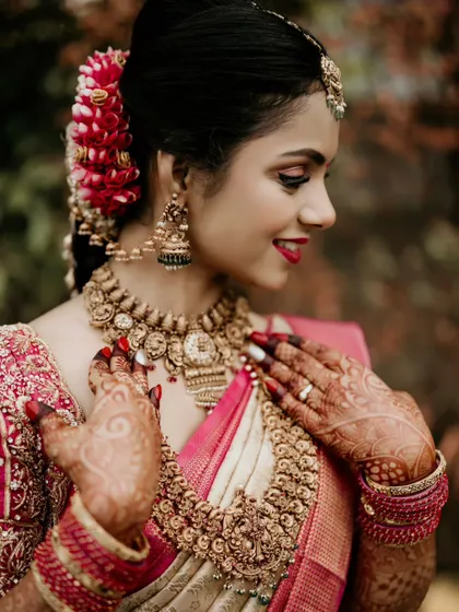 A close-up of a bride's joyful expression and her beautiful traditional jewelry.