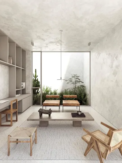 This minimalist family room is designed for quiet connection. A neutral, textured material palette creates a calming backdrop, while carefully selected wooden furniture adds warmth and character. The large window frames a private garden, bringing a sense of tranquility indoors.