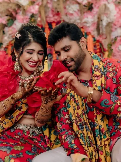 Fun and candid moments from a vibrant Mehendi event. The couple is sharing a laugh, surrounded by the bright, festive atmosphere I designed for their special day.