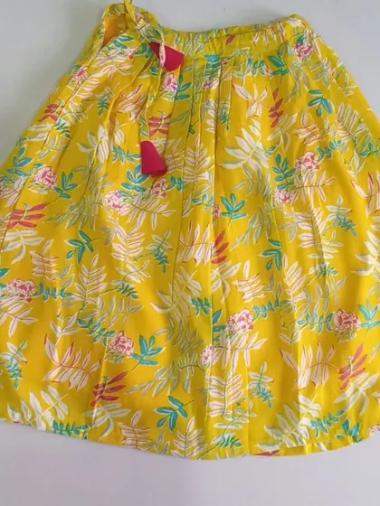 Here is the full skirt of the Meera Set. The bright yellow cotton is printed with a lovely floral design and includes a soft inner lining, plus a waist tie for easy adjustment.