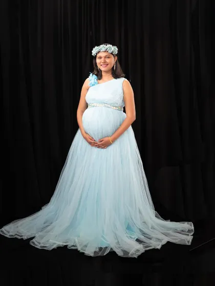 Our light blue maternity gown is perfect for a serene and classic studio portrait, complete with a matching floral crown.